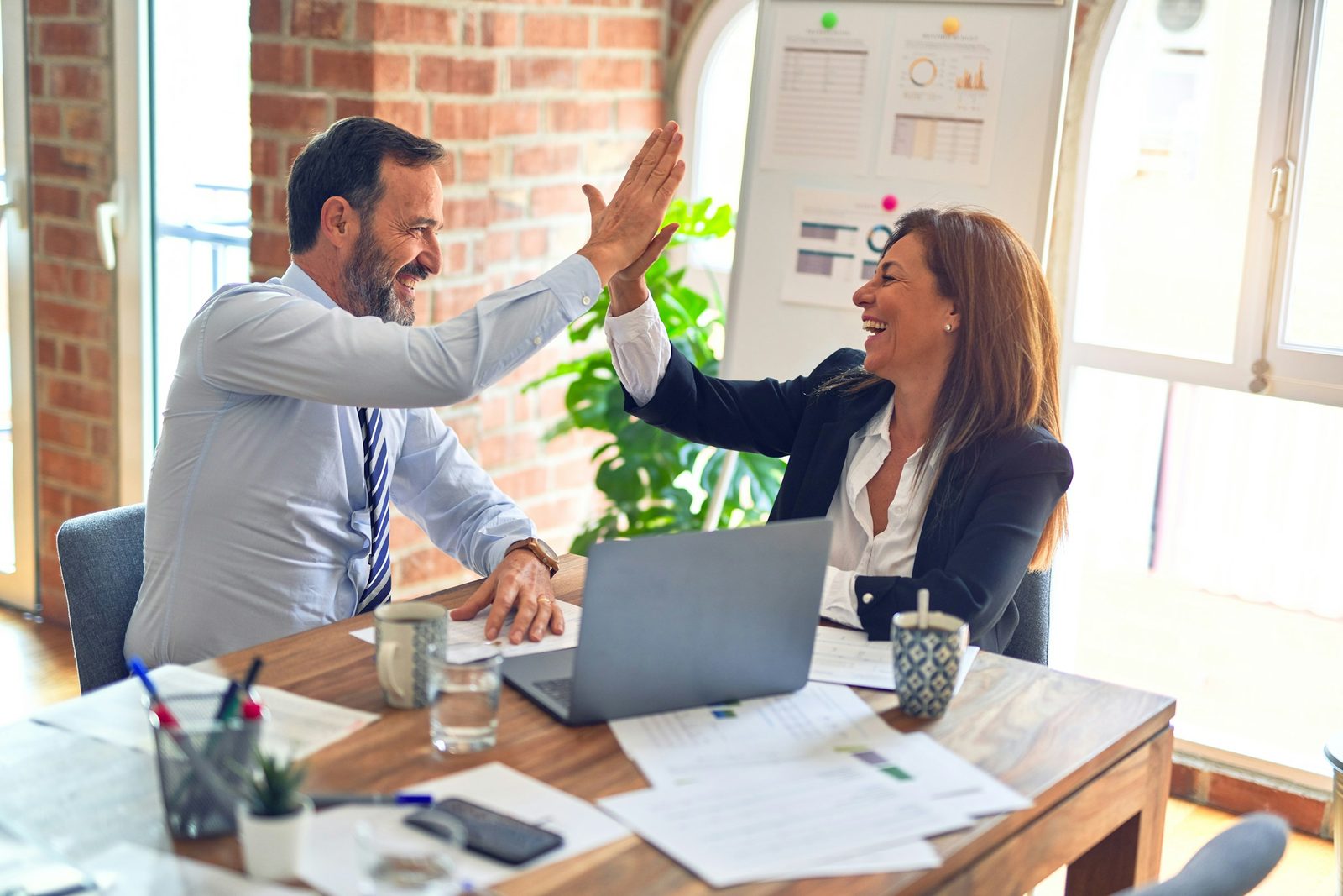 Two people shaking hands across a desk