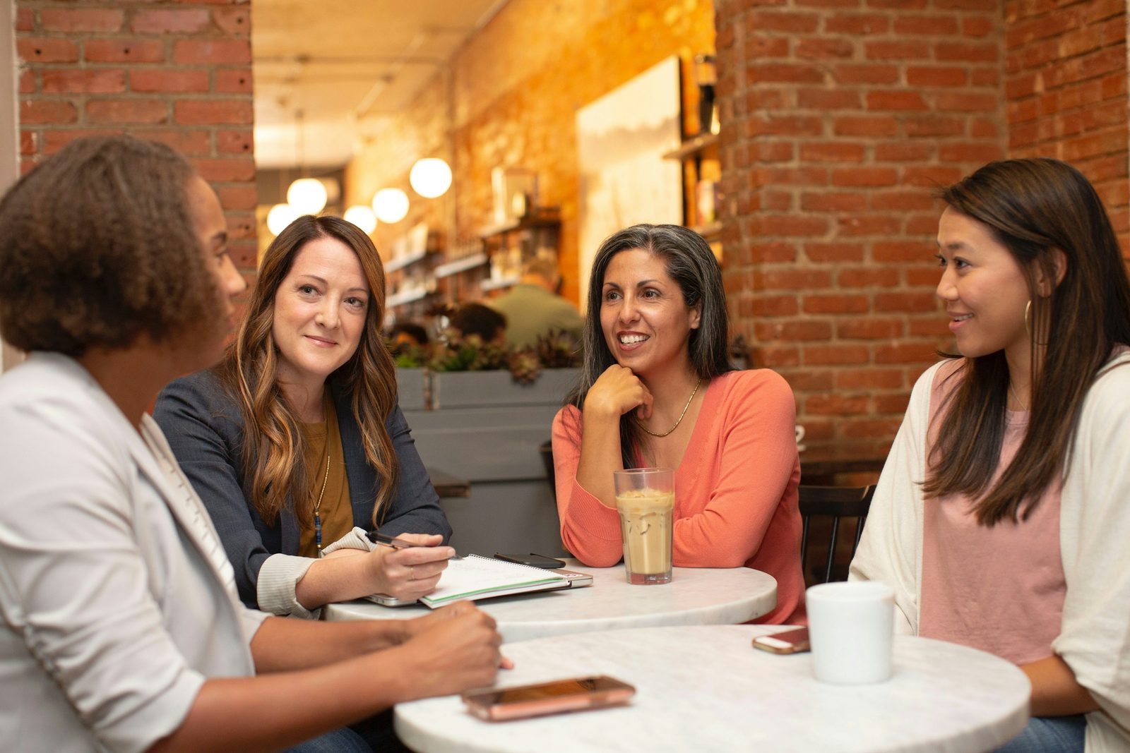 Three people talking over coffee